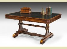 A rosewood veneered Regency period Library Table with leathered surface and detailed carving